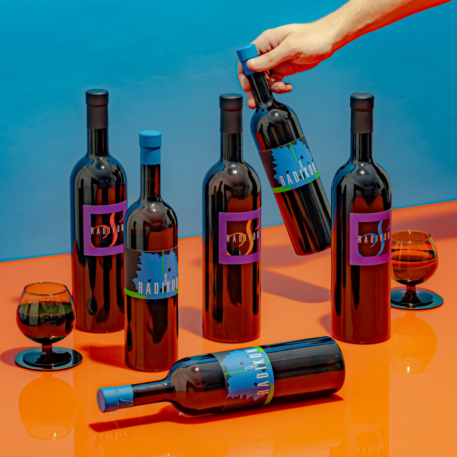 A lineup of the latest Radikon wines on a vibrant orange & blue background.