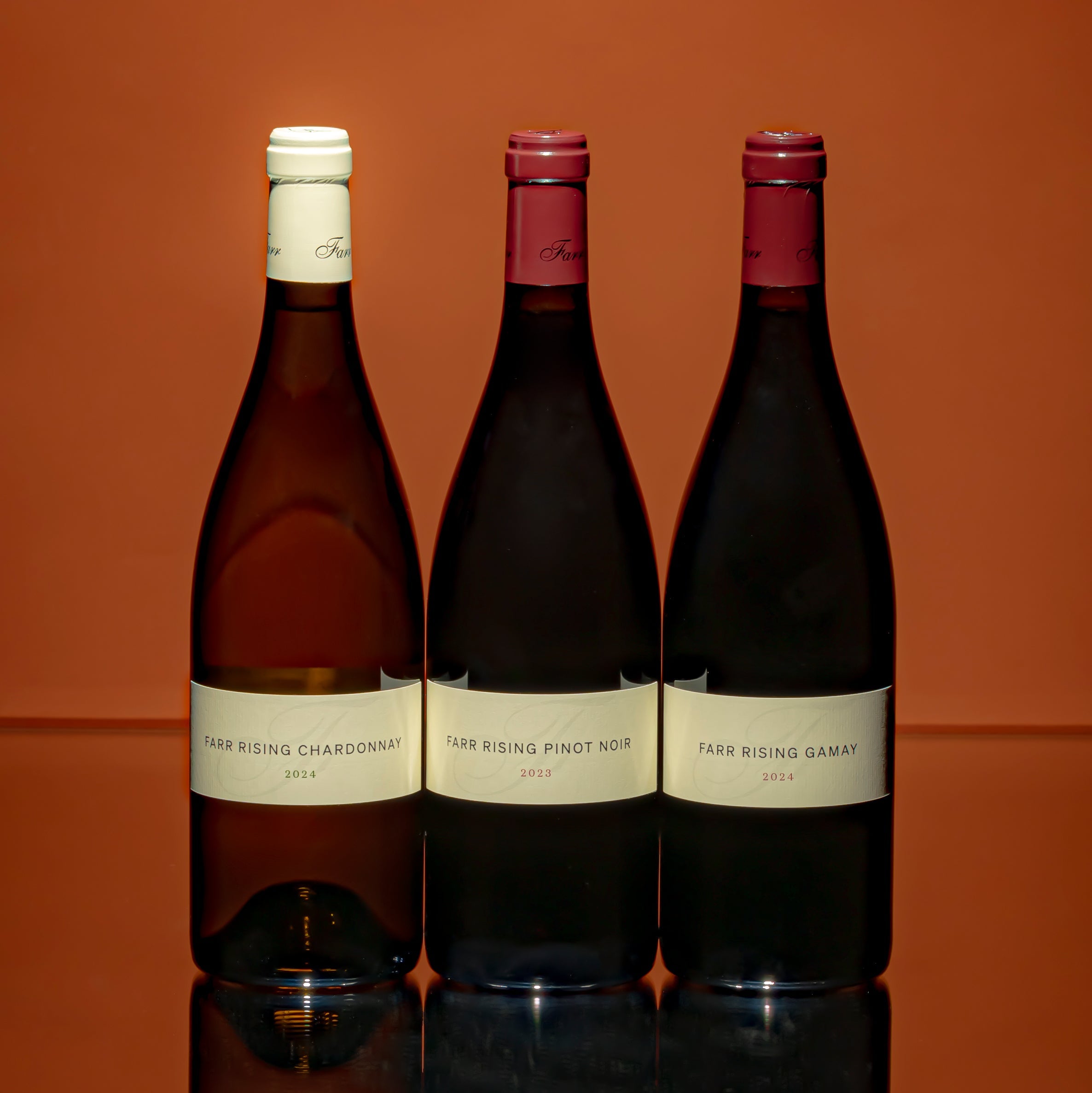 A lineup of Farr Rising's latest 2024 release of single site expression wines—Chardonnay, Pinot Noir and Gamay.